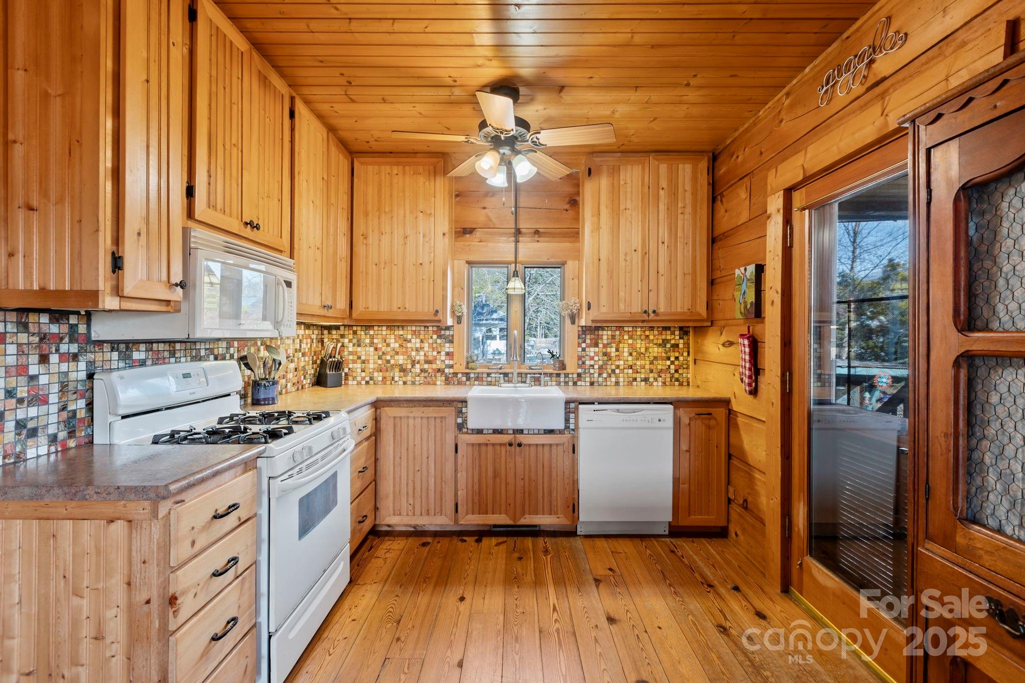 104 Enthoffer Road Black Mountain, NC 28711 - Photo 19 of 42 a kitchen with granite countertop wooden floors and white stainless steel appliances