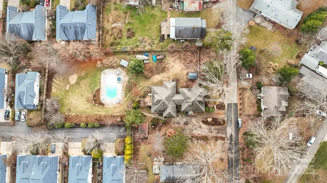 an aerial view of a house with a yard and wooden fence