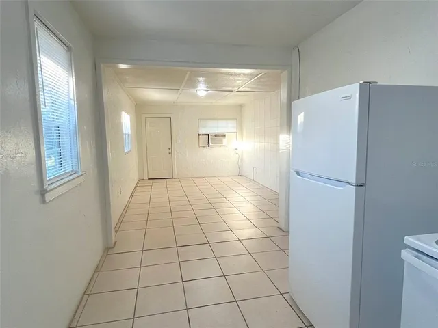 a view of empty room with windows and refrigerator