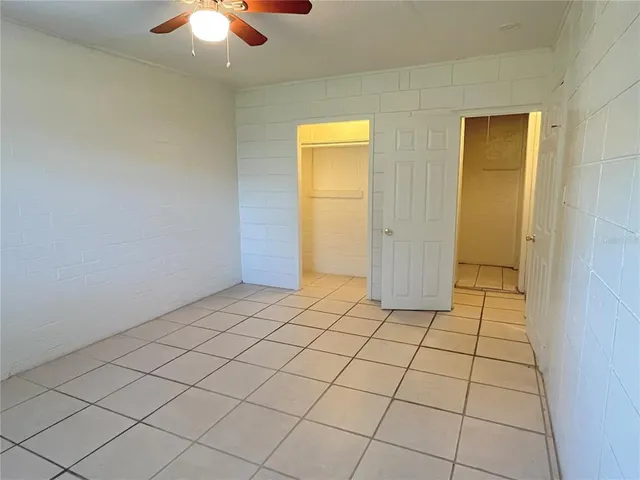 a view of a livingroom with an empty space and a chandelier fan