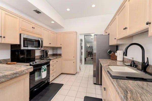 a kitchen with kitchen island granite countertop a stove and a sink