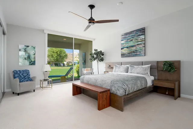 a spacious bedroom with a bed a table and a painting on the wall
