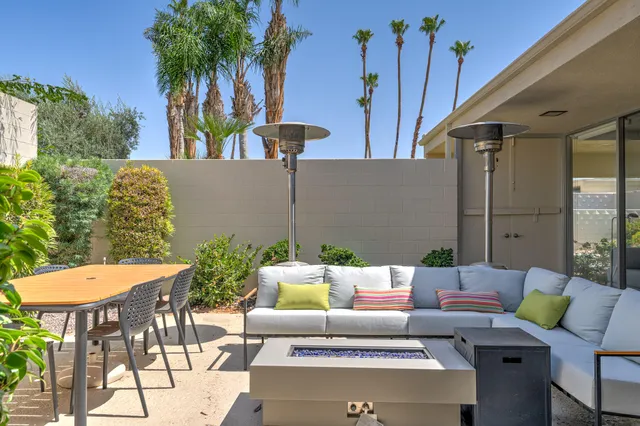 a backyard of a house with fire pit and outdoor seating