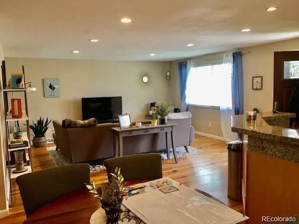 a living room with furniture a flat screen tv and a window