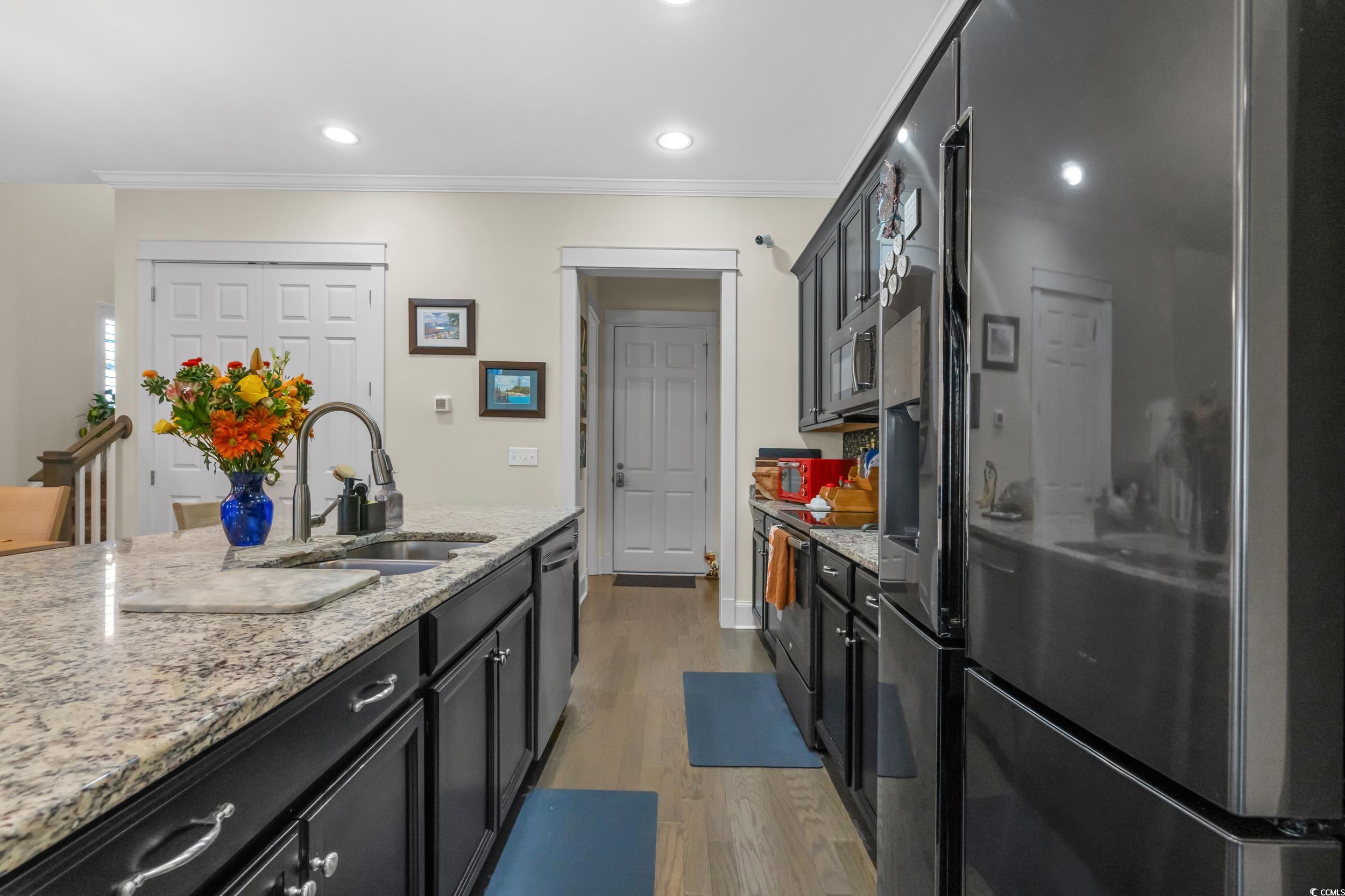 2794E Howard Avenue, Unit A Myrtle Beach, SC 29577 - Photo 14 of 40 Kitchen featuring stainless steel appliances, dark cabinetry, light stone countertops, recessed lighting, and crown molding