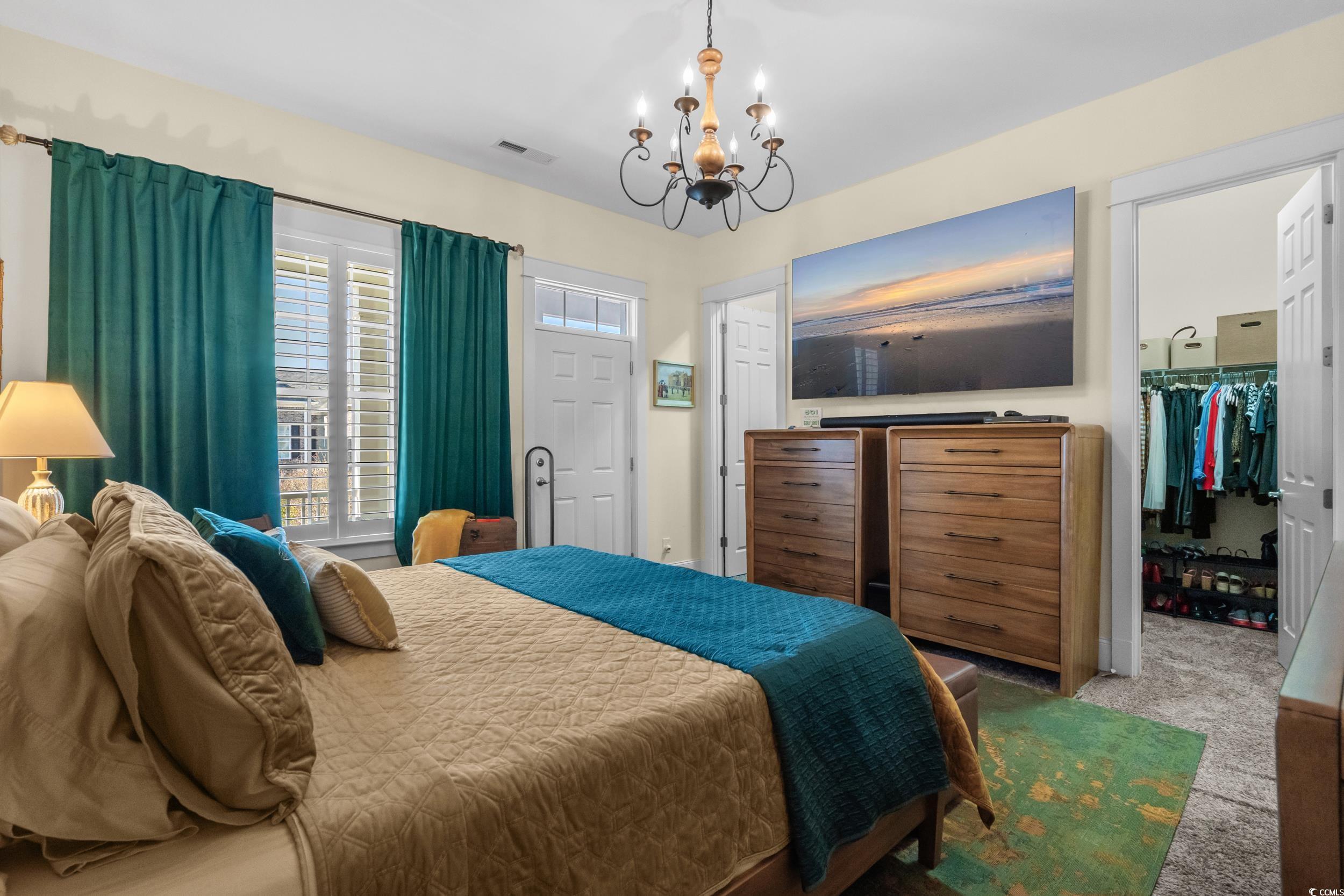 2794E Howard Avenue, Unit A Myrtle Beach, SC 29577 - Photo 17 of 40 Bedroom featuring a spacious closet, carpet floors, and a chandelier