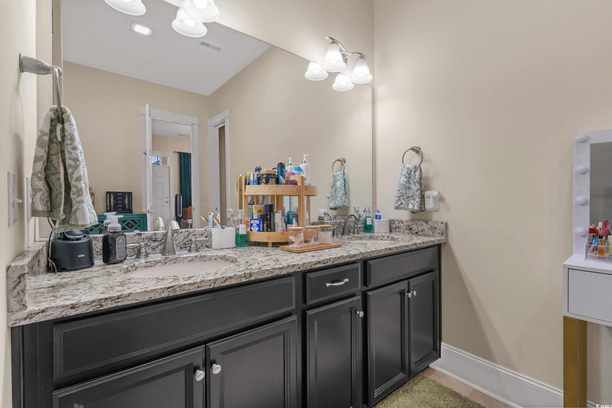 2794E Howard Avenue, Unit A Myrtle Beach, SC 29577 - Photo 20 of 40 Full bathroom with double vanity, light tile patterned floors, and a chandelier