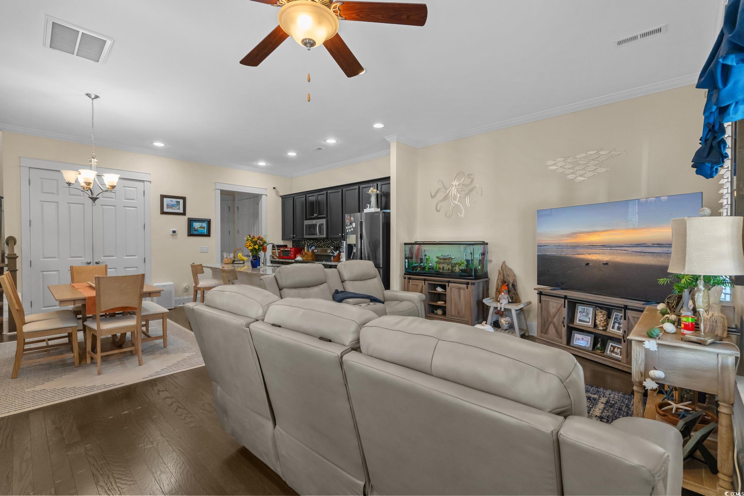 2794E Howard Avenue, Unit A Myrtle Beach, SC 29577 - Photo 6 of 40 Living room featuring ornamental molding, dark wood-style flooring, recessed lighting, ceiling fan, and a chandelier