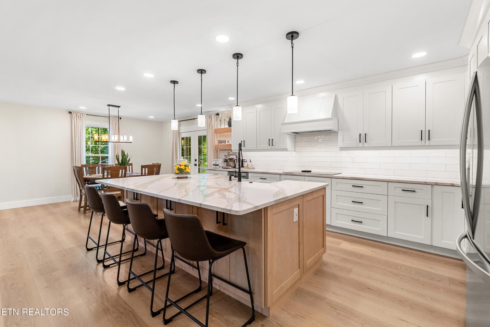 337 Farmer's Hollow Road Clinton, TN 37716 - Photo 16 of 49 a kitchen with stainless steel appliances kitchen island granite countertop a table chairs in it and white cabinets