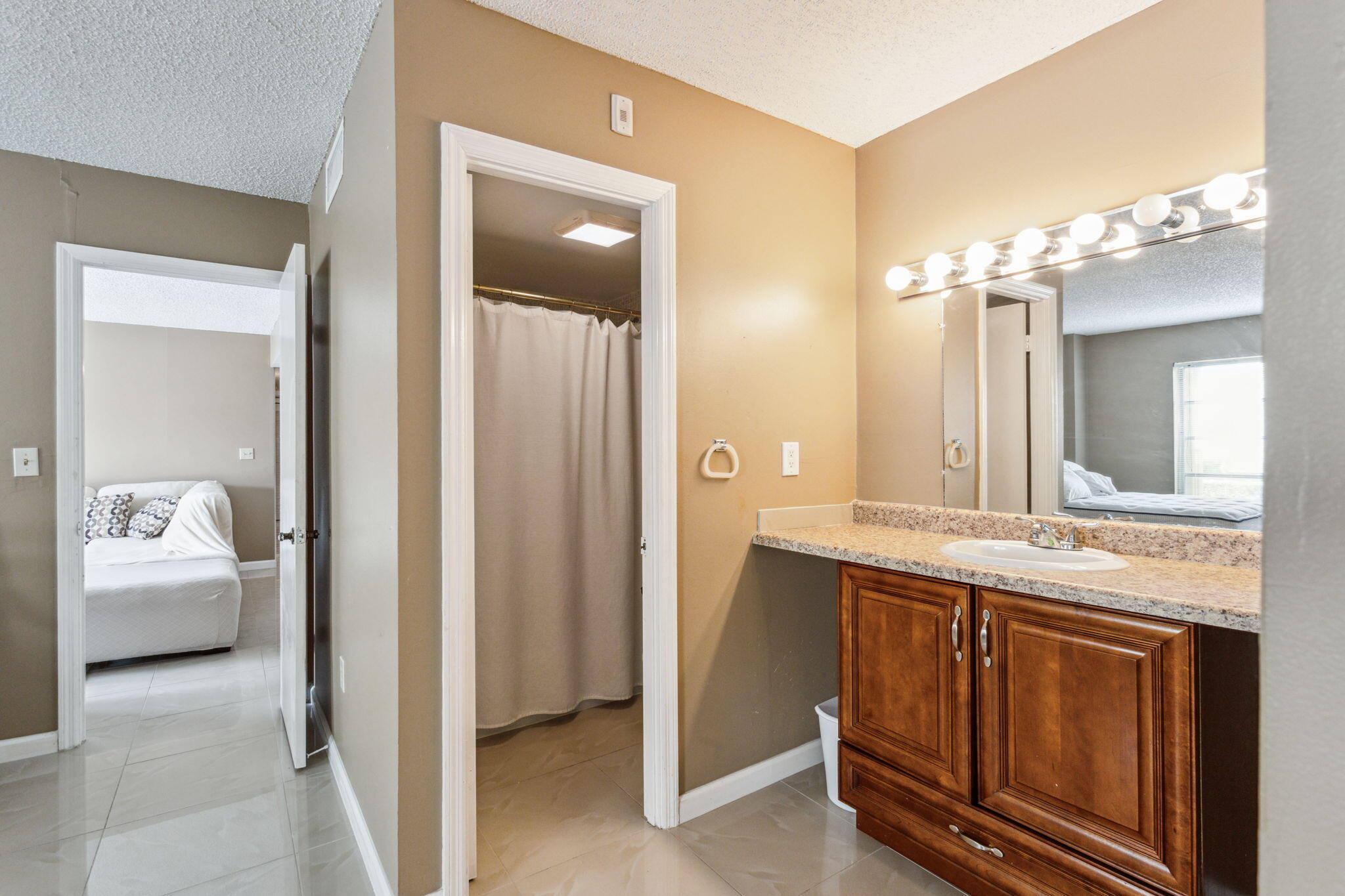 951 De Soto Road, Unit 2300 Boca Raton, FL 33432 - Photo 13 of 29 a en suite bathroom with a granite countertop sink and a mirror