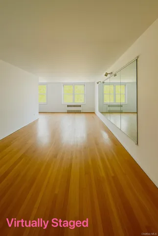 a view of empty room with wooden floor