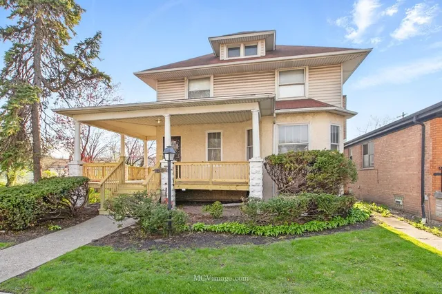 a view of a white house next to a yard with plants and trees