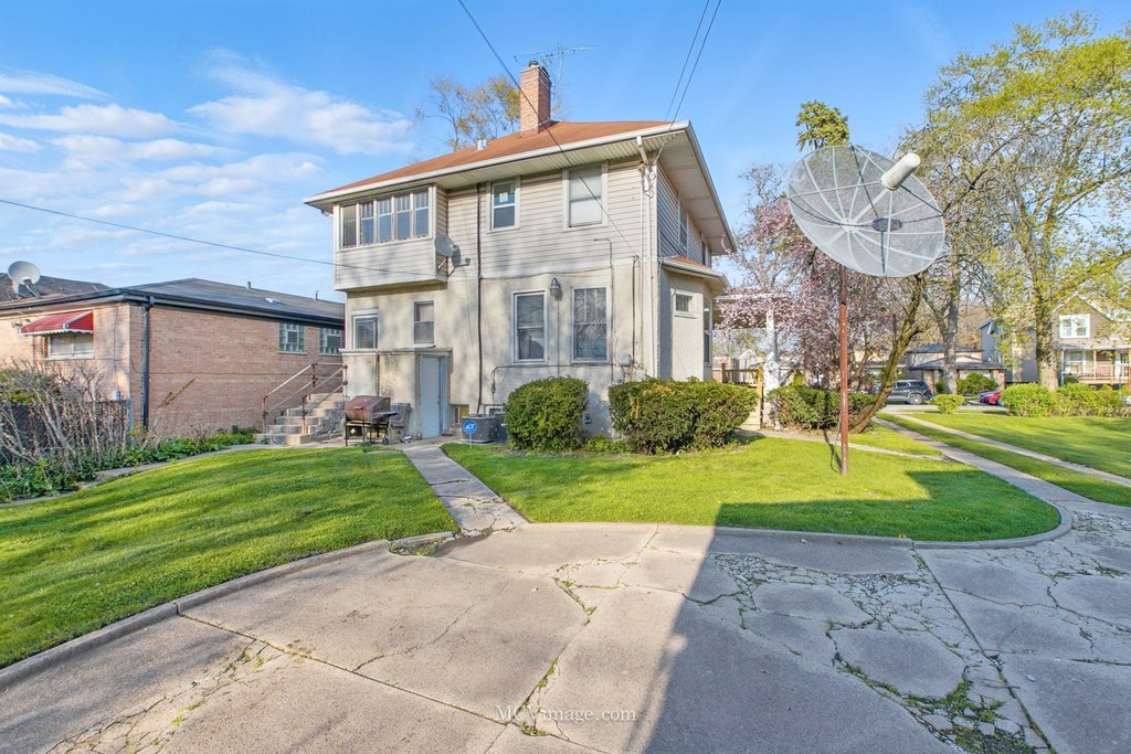10130 South Lowe Avenue Chicago, IL 60628 - Photo 22 of 23 a front view of a house with a yard and garage