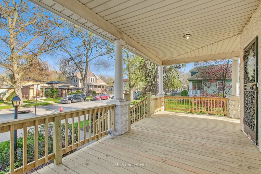 10130 South Lowe Avenue Chicago, IL 60628 - Photo 4 of 23 a view of a porch with wooden floor and fence