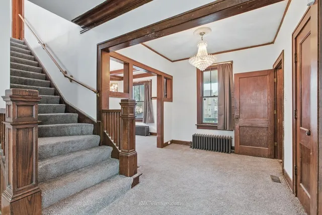a view of entryway and hall with wooden floor and windows