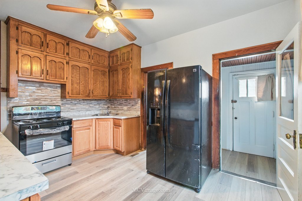 10130 South Lowe Avenue Chicago, IL 60628 - Photo 10 of 23 a kitchen with stainless steel appliances granite countertop a refrigerator and a stove top oven
