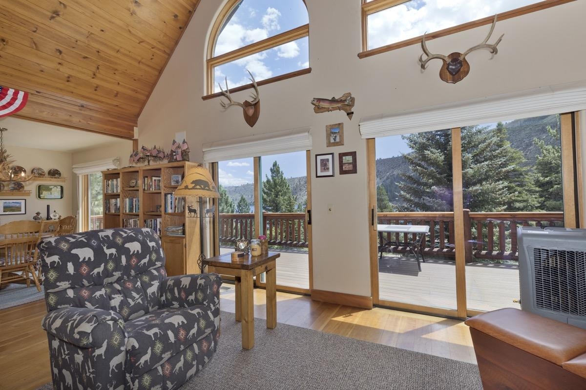 Living area featuring wooden ceiling, high vaulted ceiling, a mountain view, and wood finished floors