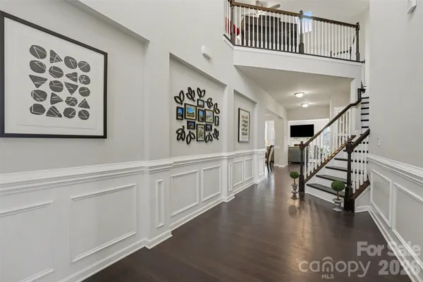 a hallway with white cabinets and wooden floor