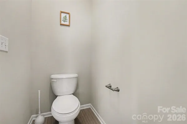a white toilet sitting next to a white wall