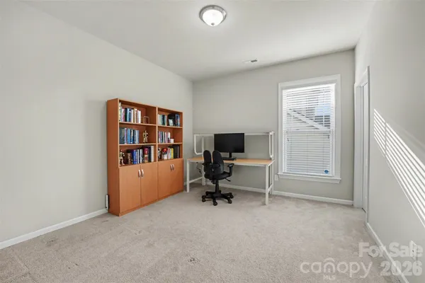a view of a workspace with furniture and a window