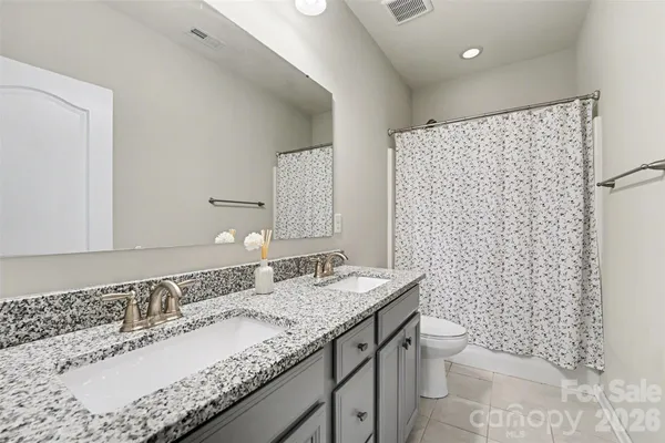 a bathroom with a granite countertop sink a toilet and a mirror