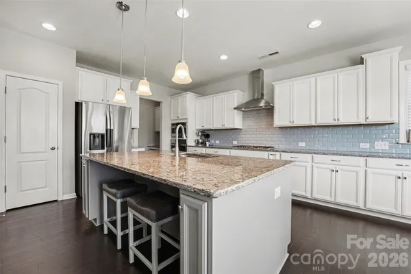 a kitchen with stainless steel appliances granite countertop a sink a stove and a refrigerator