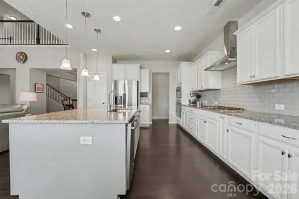 a large kitchen with stainless steel appliances lots of counter space and a sink