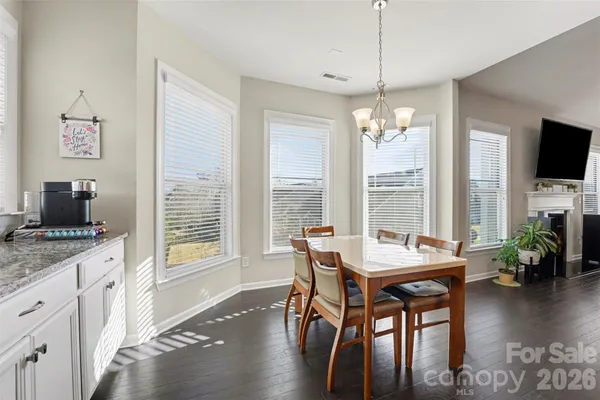 a dining room with furniture window wooden floor and a chandelier