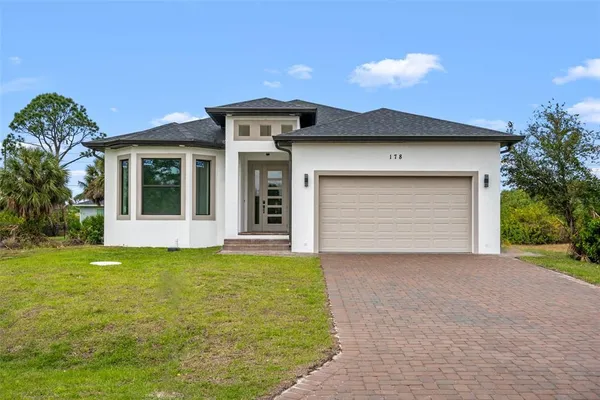 a view of a house with a yard and garage