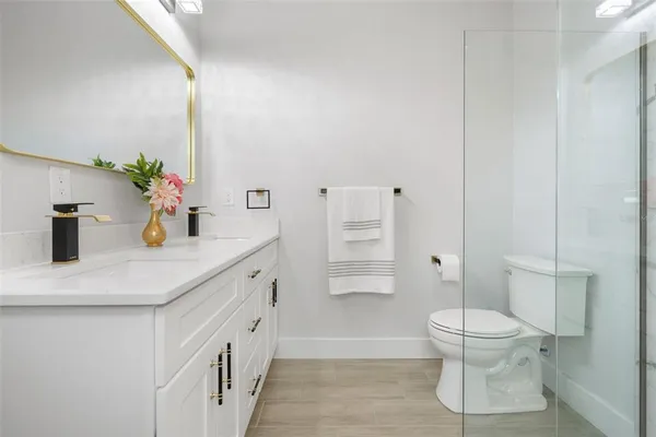 a bathroom with a sink a toilet and shower