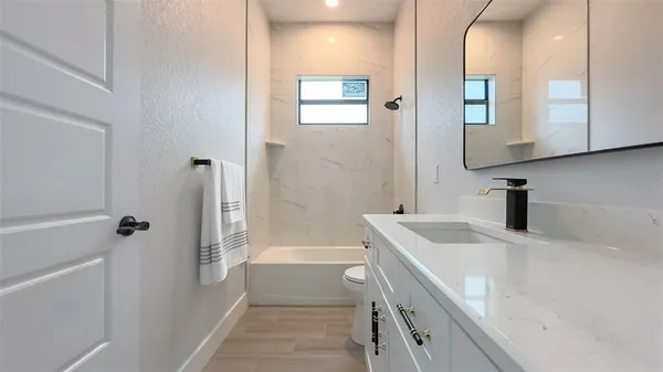 a bathroom with a tub sink and mirror