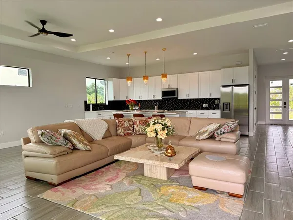 a living room with furniture kitchen view and a window