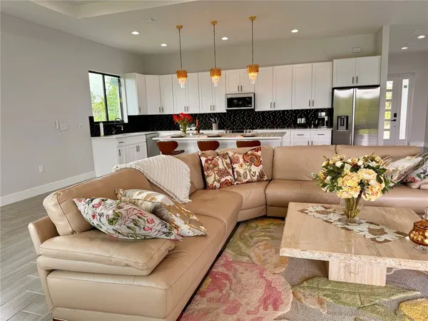 a living room with furniture kitchen and a large window