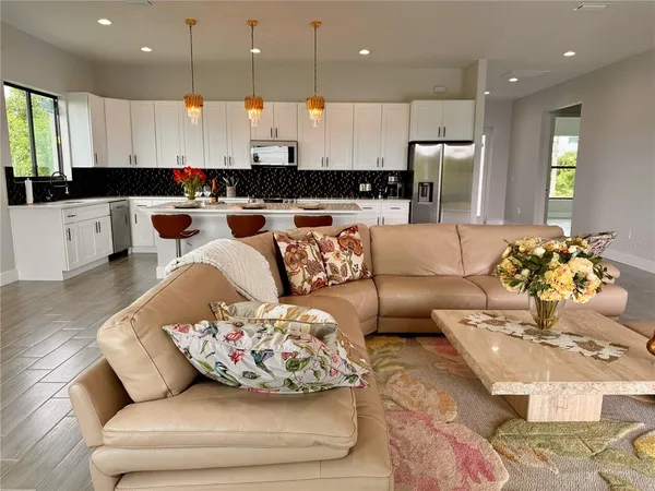 a living room with furniture and kitchen view