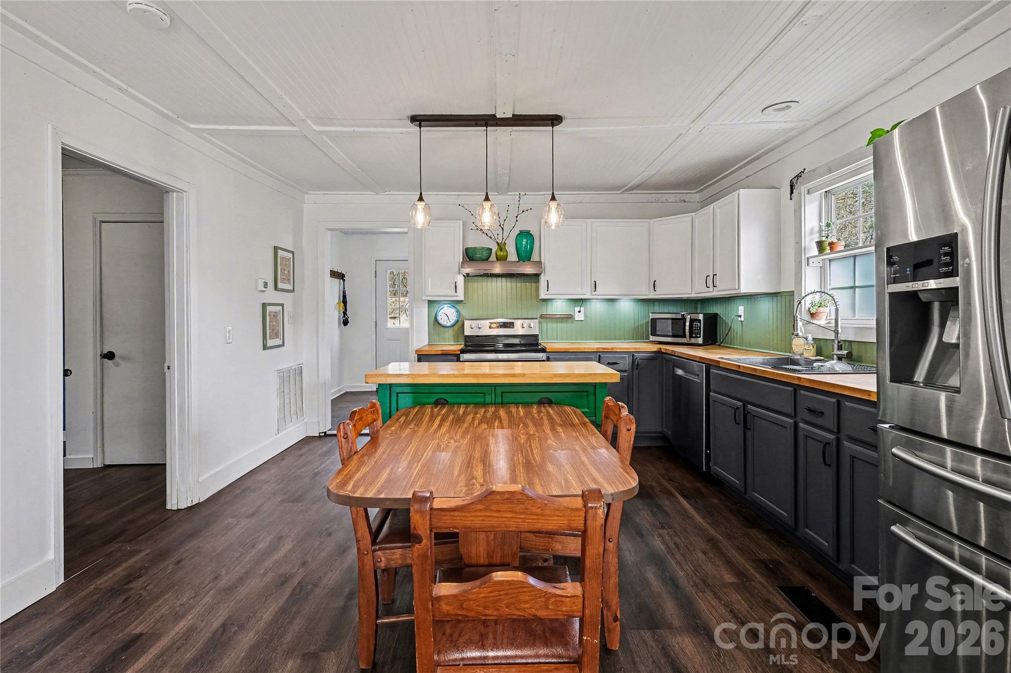 1175 Old Salisbury-Concord Road Concord, NC 28025 - Photo 22 of 31 a kitchen with stainless steel appliances a dining table chairs stove and refrigerator