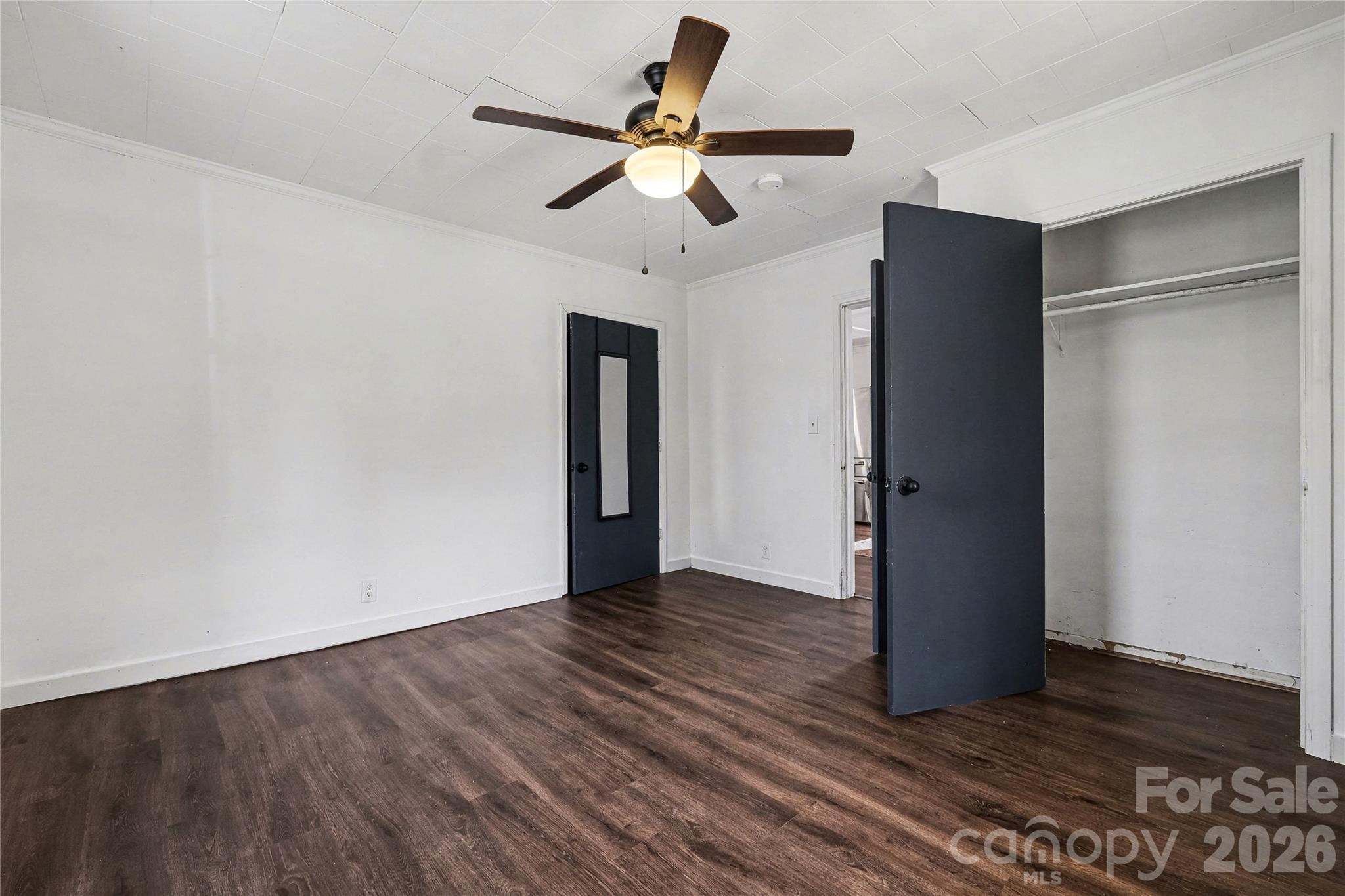 1175 Old Salisbury-Concord Road Concord, NC 28025 - Photo 10 of 31 a view of an empty room with wooden floor and a ceiling fan
