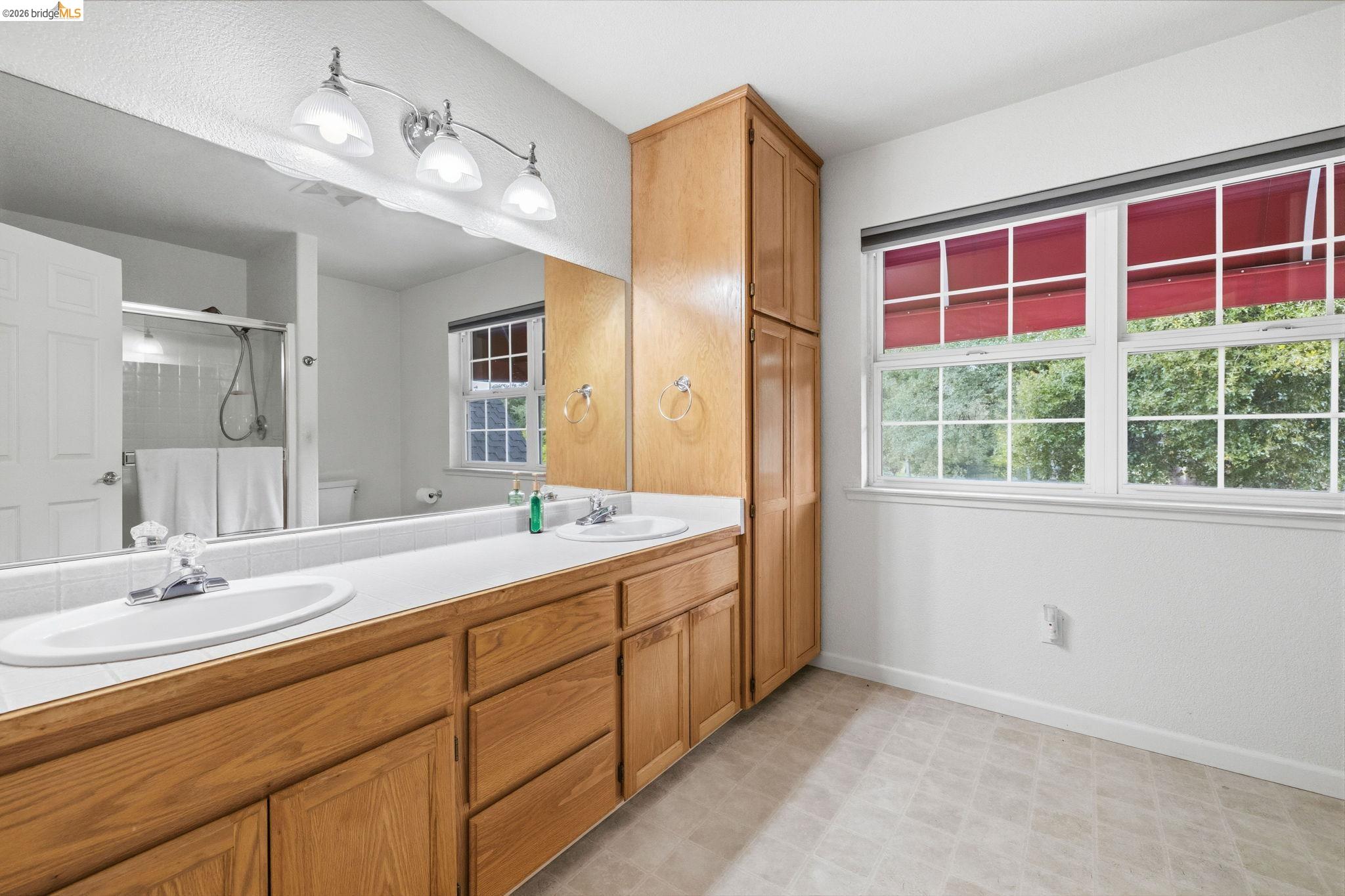 18450 Lambert Lake Road Sonora, CA 95370 - Photo 59 of 87 Dual vanity with integrated sinks, wood-finish cabinetry, and a full-width mirror