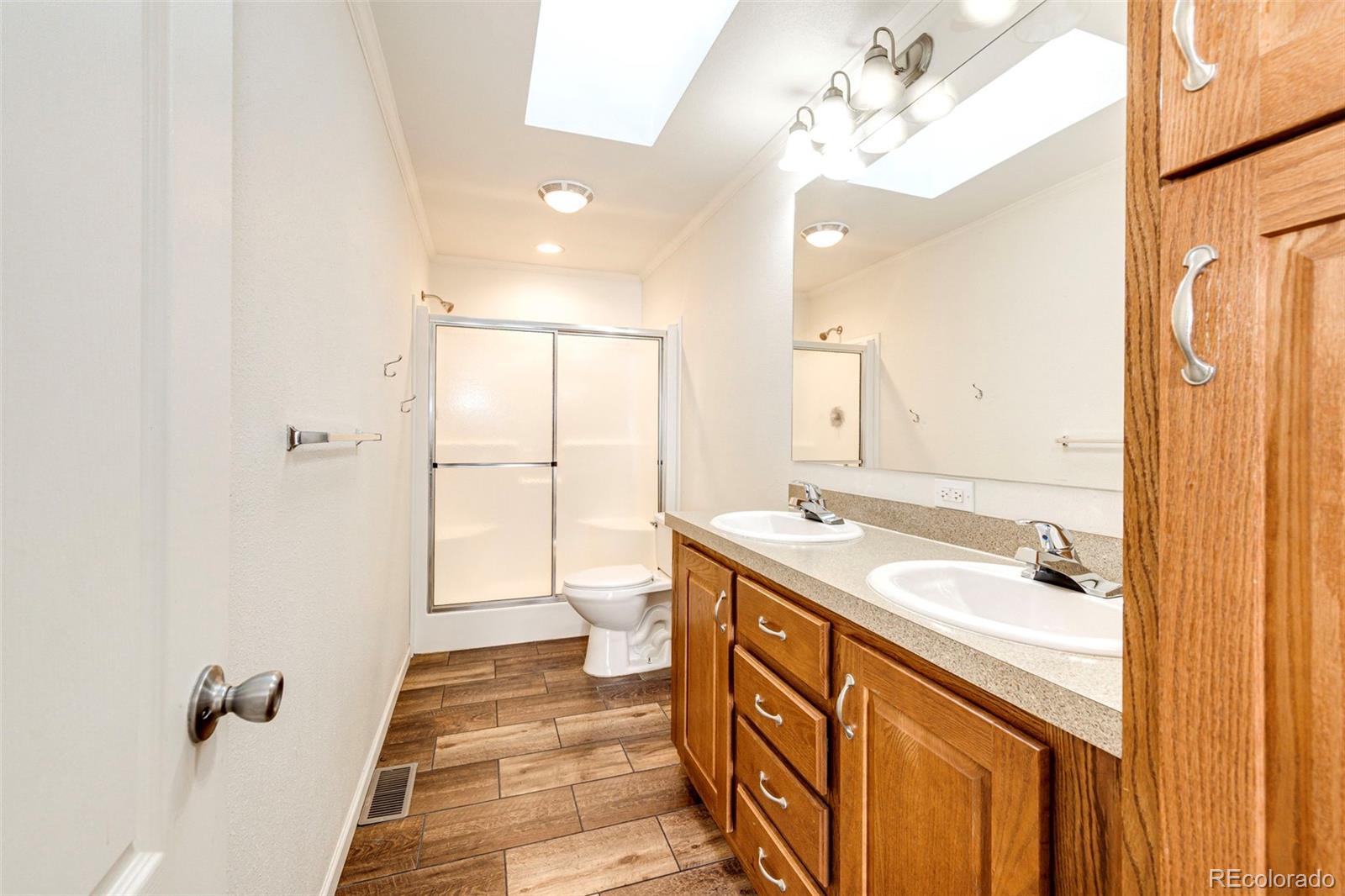 574 4th Street Bennett, CO 80102 - Photo 14 of 24 a bathroom with a sink a mirror and a shower