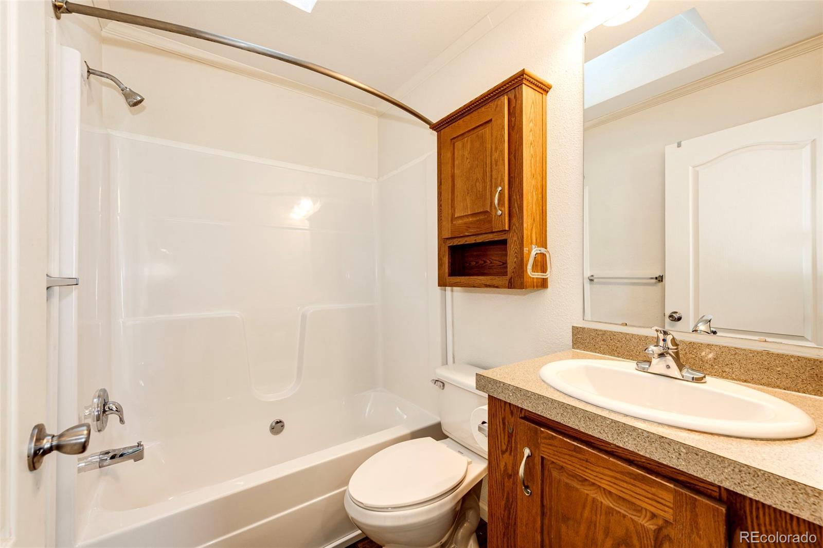 574 4th Street Bennett, CO 80102 - Photo 19 of 24 a bathroom with a sink toilet and shower