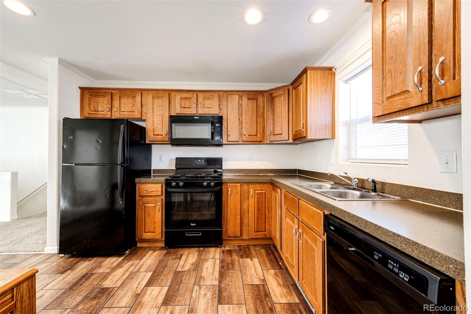 574 4th Street Bennett, CO 80102 - Photo 8 of 24 a kitchen with granite countertop a refrigerator stove and sink