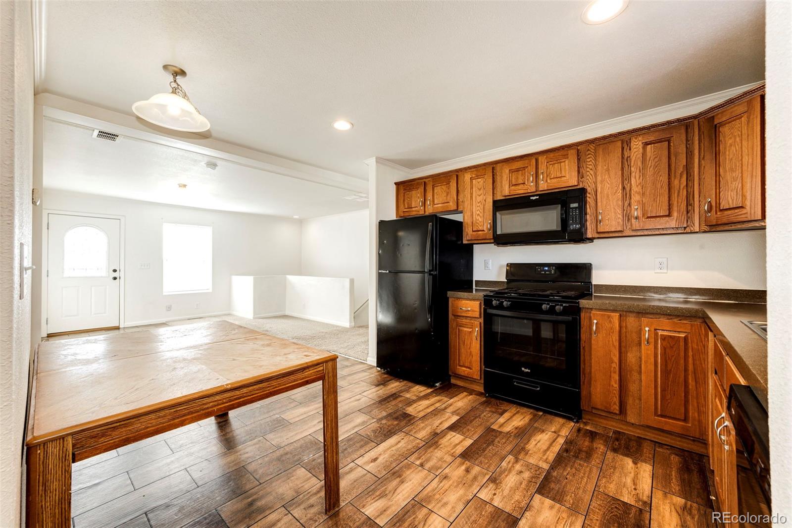 574 4th Street Bennett, CO 80102 - Photo 9 of 24 a kitchen with stainless steel appliances granite countertop a refrigerator and a stove top oven
