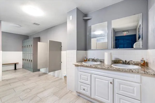 a large bathroom with a granite countertop sink a toilet and a bathtub