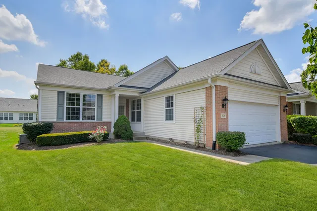 a front view of a house with a yard and outdoor seating