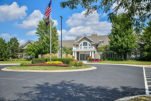 a front view of a house with a yard and trees