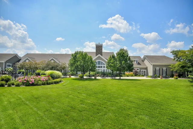 a front view of a house with garden and trees