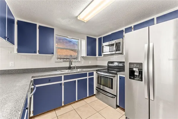 a kitchen with stainless steel appliances granite countertop a stove sink and refrigerator
