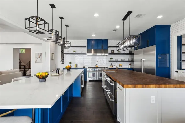 a kitchen with stainless steel appliances granite countertop a sink a stove and a wooden floors