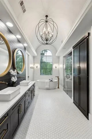 a large bathroom with a large window vanity and a chandelier