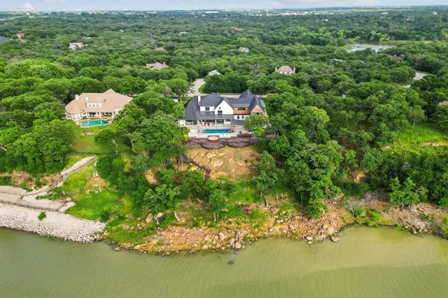 an aerial view of residential houses with outdoor space and lake view