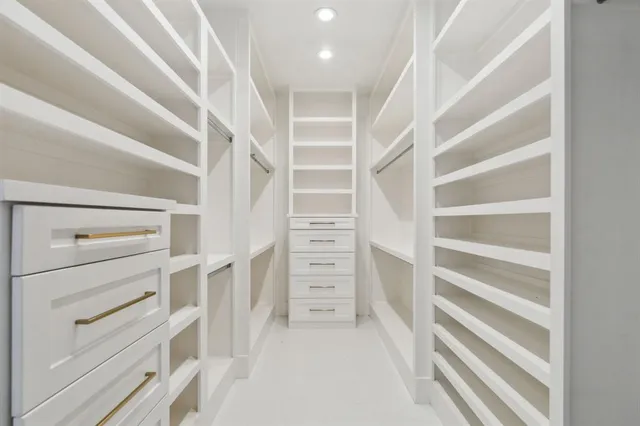 a view of walk in closet with empty racks